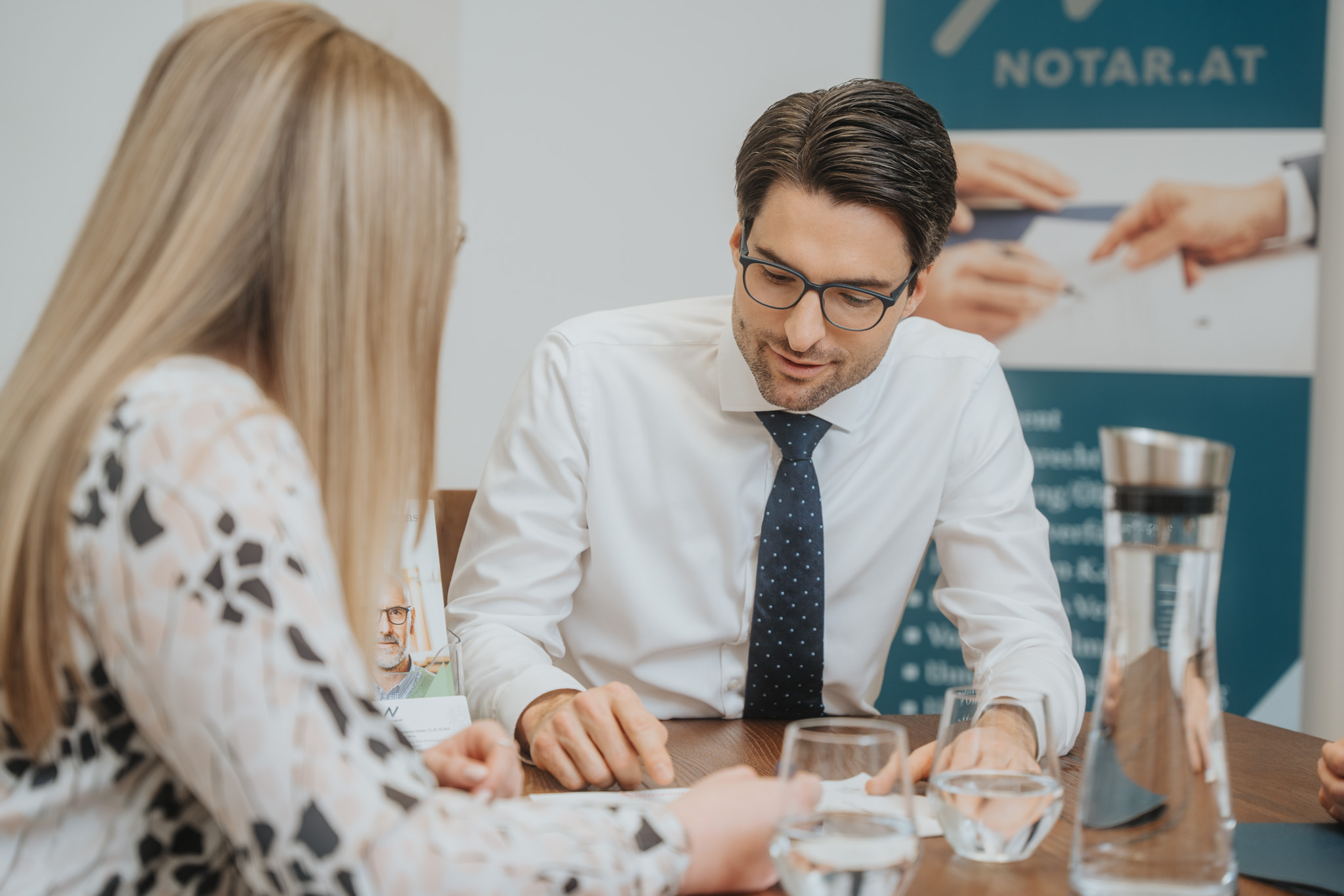 Christian Huber Notar in Besprechung Christian Huber Notar aus Windischgarsten sitzt mit einer Klientin am Tisch. Sie besprechen zusammen einen Vertrag. GmbH
